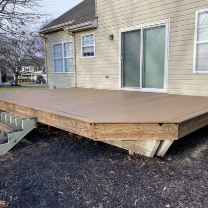 Photo of composite deck boards being installed on deck framing and deck steps being added