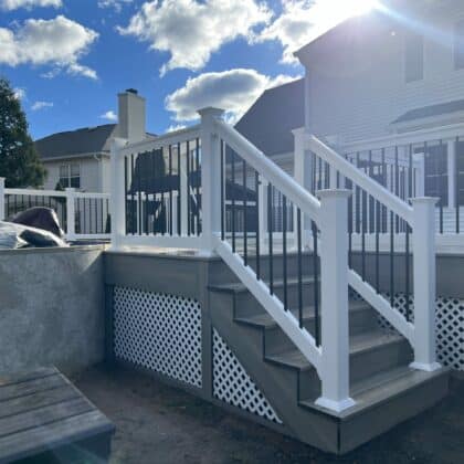 Photo of deck, white railing, black balusters, and deck steps