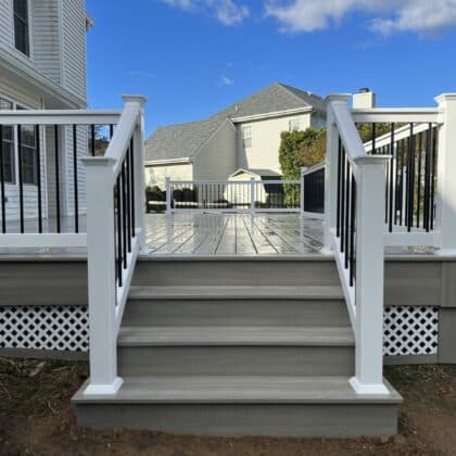 Photo of deck, white railing, black balusters, and deck steps