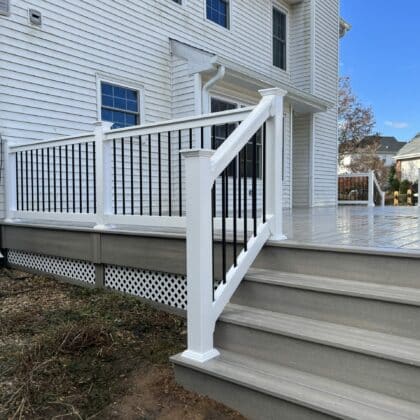 Photo of deck, white railing, black balusters, and deck steps