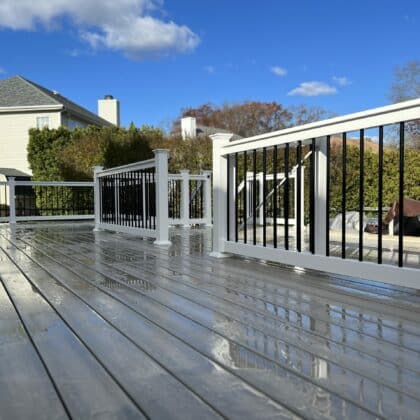 Photo of deck, white railing, black balusters