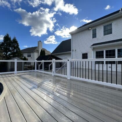 Photo of curved pool deck that is fenced and gated off from rest of deck