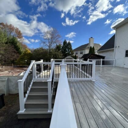 Wide view of composite deck, white deck railing and deck steps