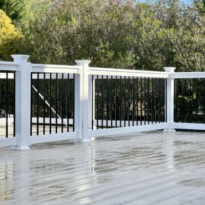 Wide view of composite deck, white deck railing and deck steps