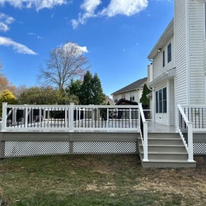 Wide view of composite deck, white deck railing and deck steps