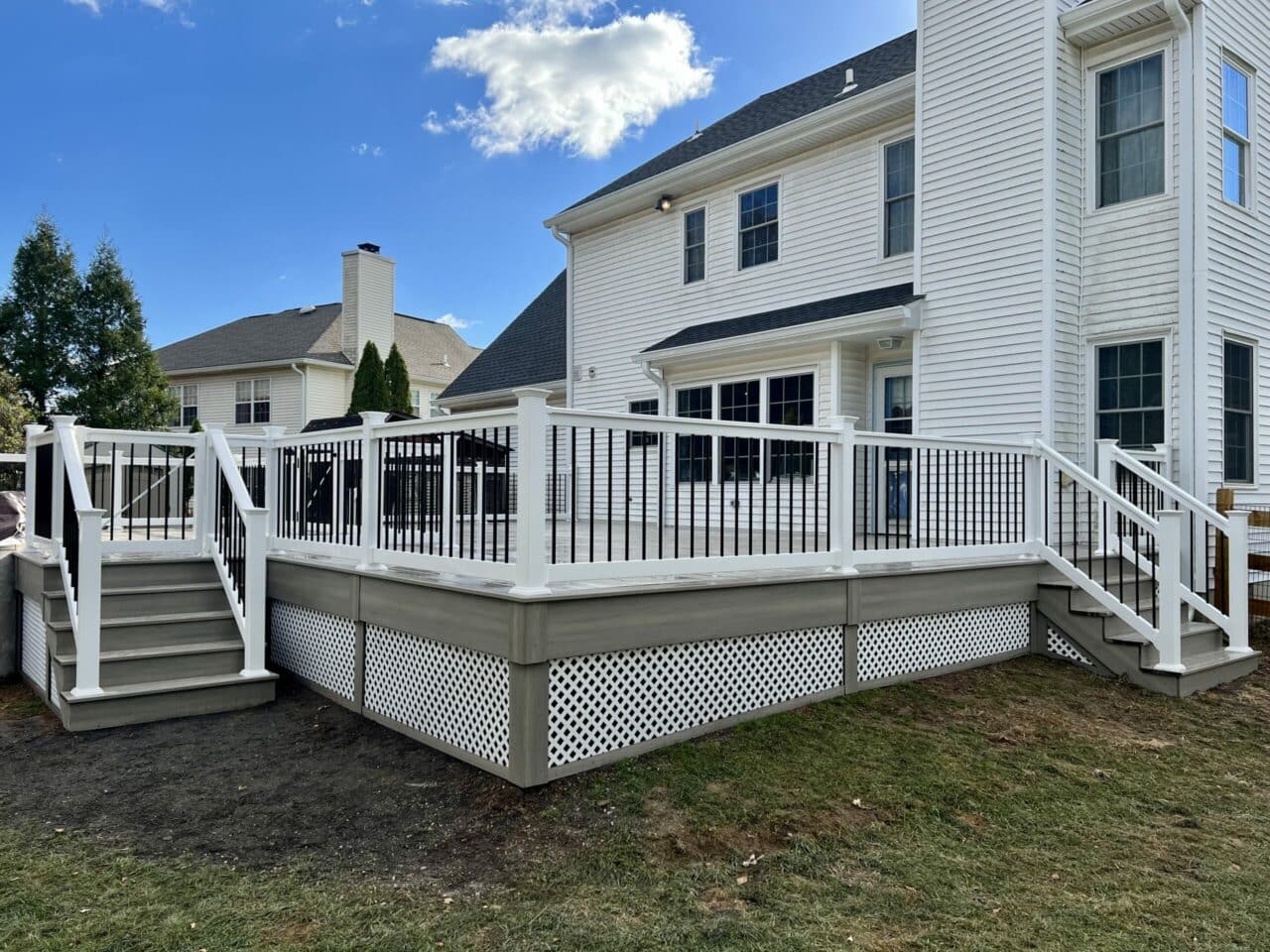 Wide view of composite deck, white deck railing and deck steps