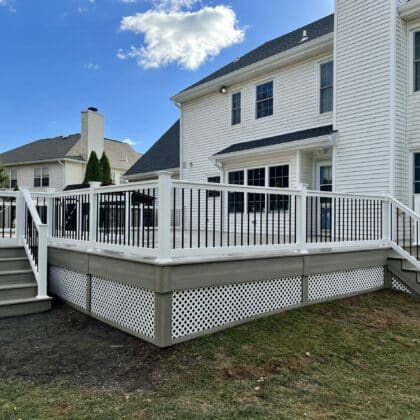 Wide view of composite deck, white deck railing and deck steps