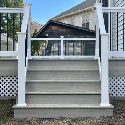 Photo of white deck railing and deck steps leading to deck
