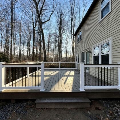 Photo of a new deck with white railing and black balusters