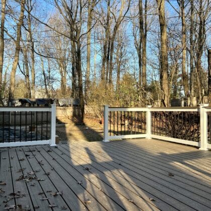 Photo of a new deck with white railing and black balusters