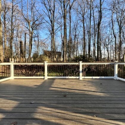 Photo of a new deck with white railing and black balusters