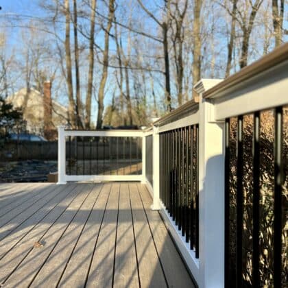 Photo of a new deck with white railing and black balusters
