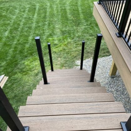 Composite deck with stairs and black aluminum railing