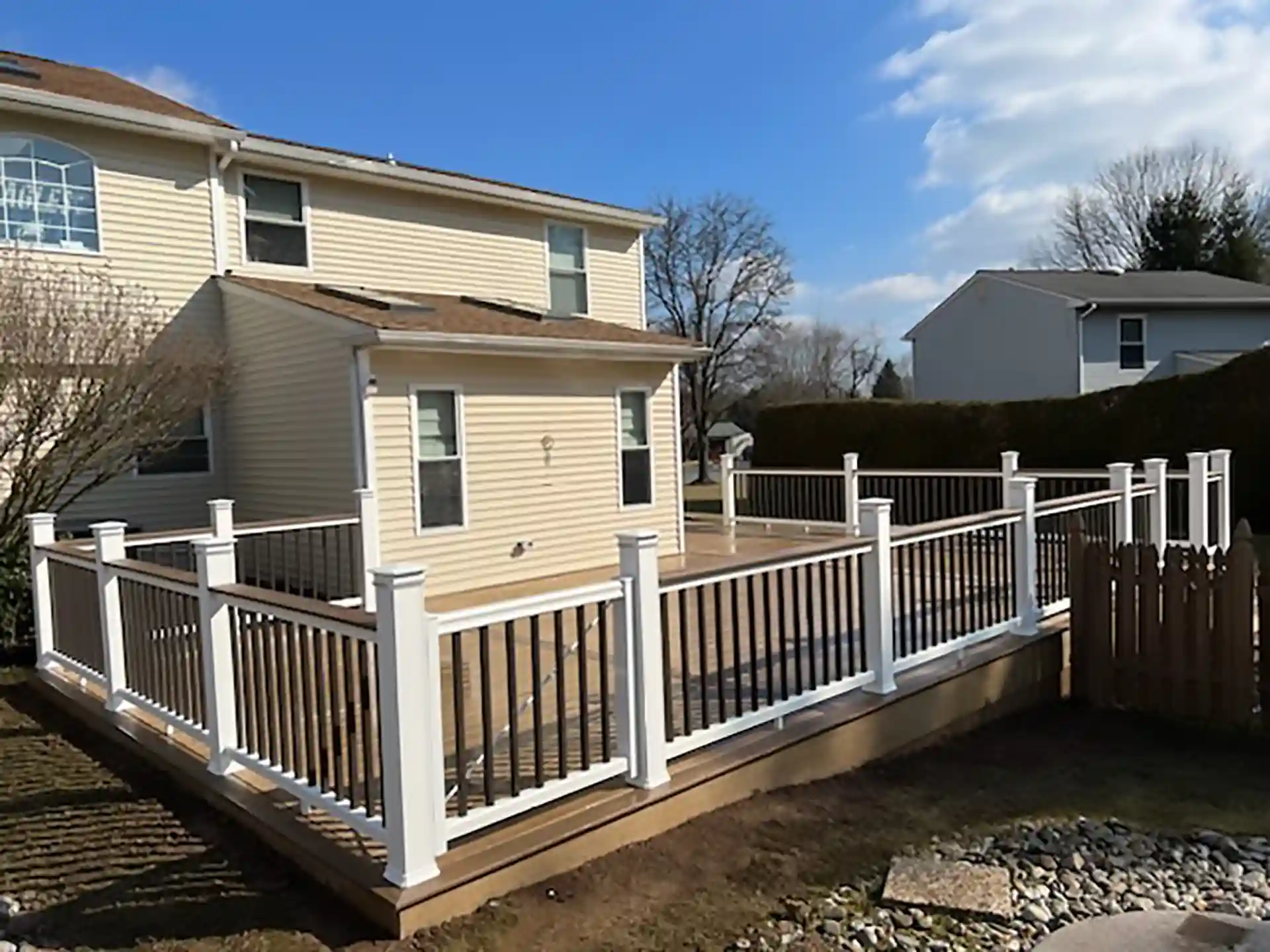 Photo of a wrap-around composite deck with deck railing and deck gate. 