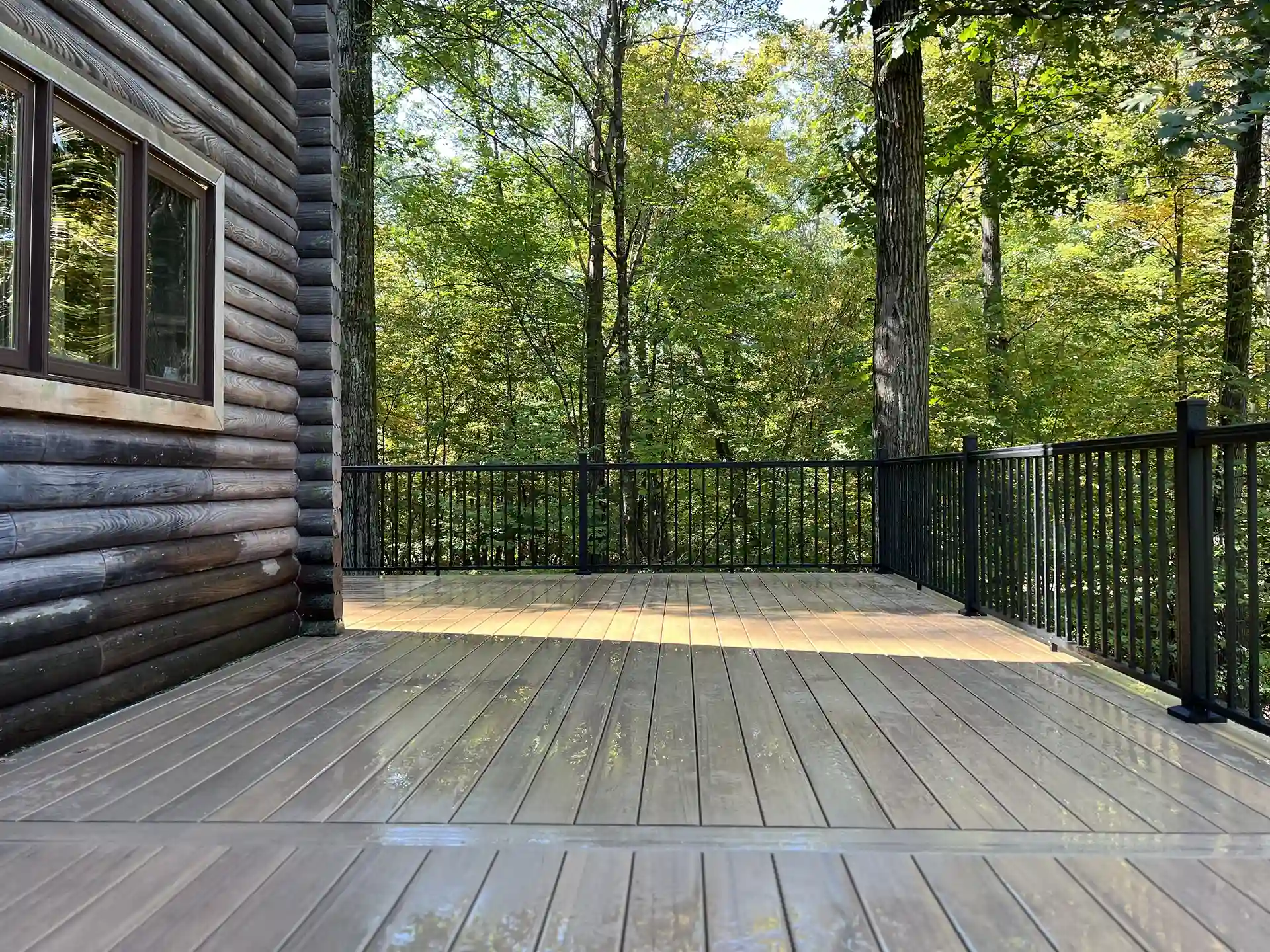 Photo of a wrap-around deck with black deck railing. 