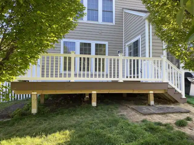 finished Timbertech decking project with white vinyl railings and lighting - Deck building company near me in Chester Springs PA