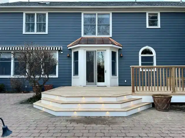 Photo of an open wood deck platform with wooden railing and step lights - Wood Deck Railing Project