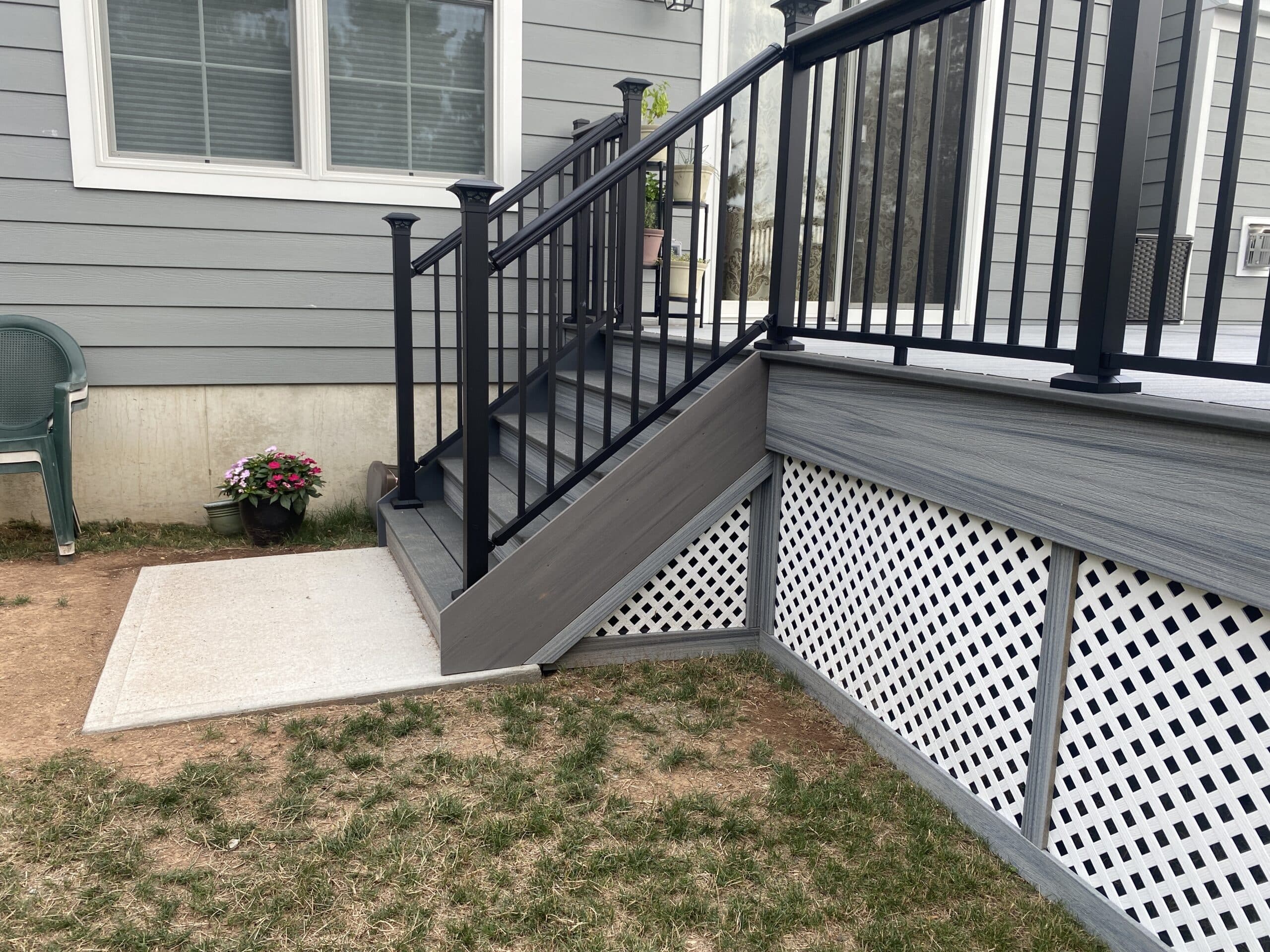 deck with composite deck boards, black metal railing, and lattice deck skirting