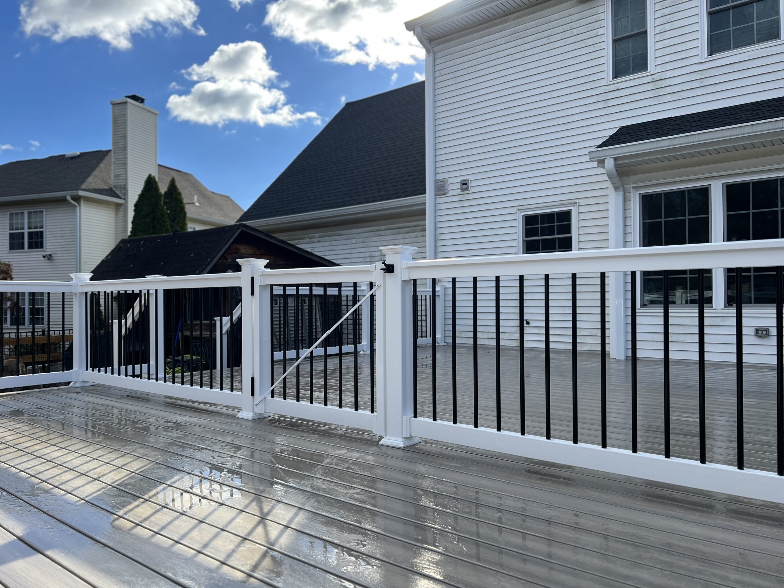 pool deck with a deck railing system that features white composite posts and rails and black balusters