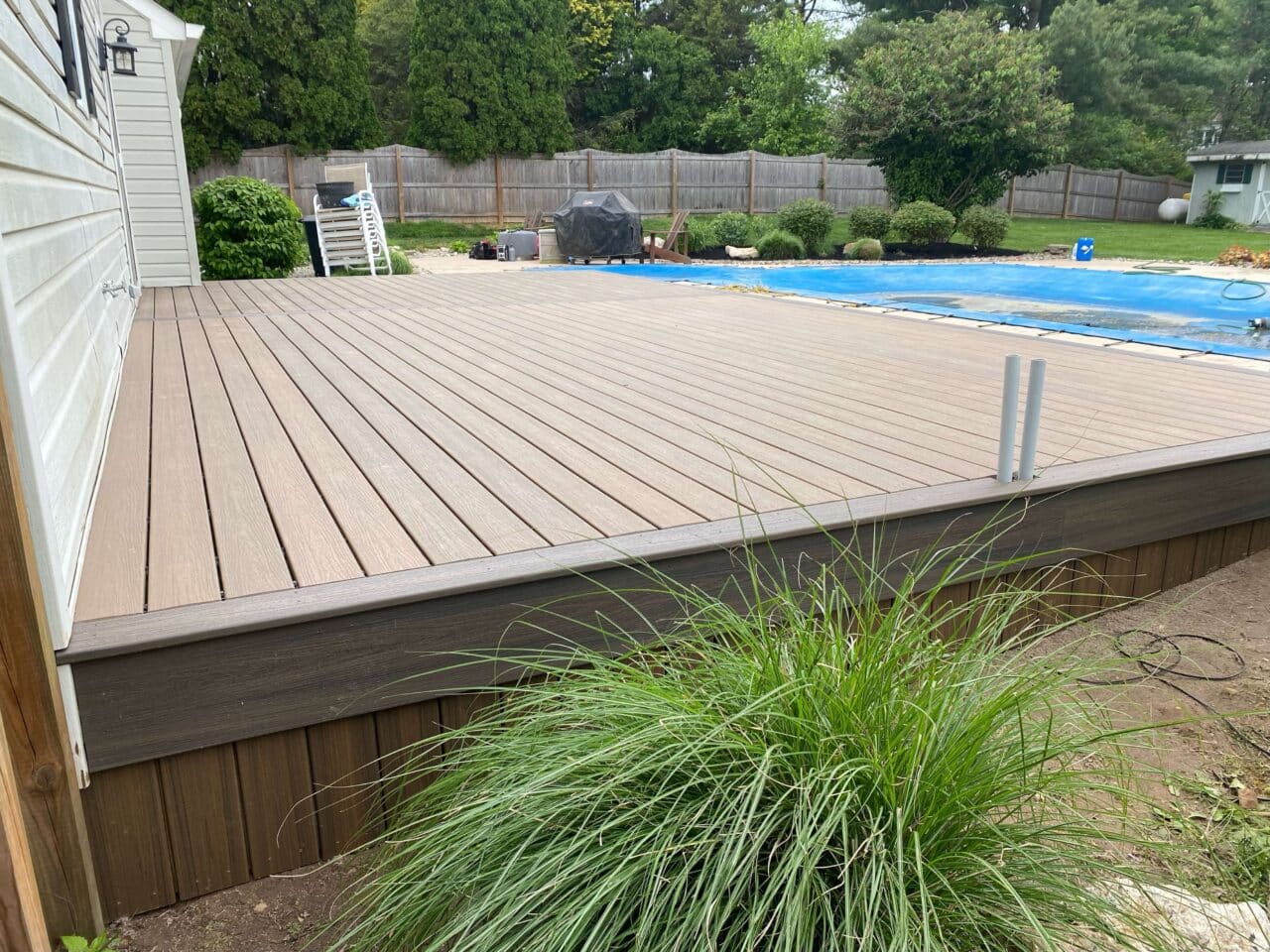 photo of a composite deck with an in-ground pool with a concrete deck - Pool Deck building company near me in PA