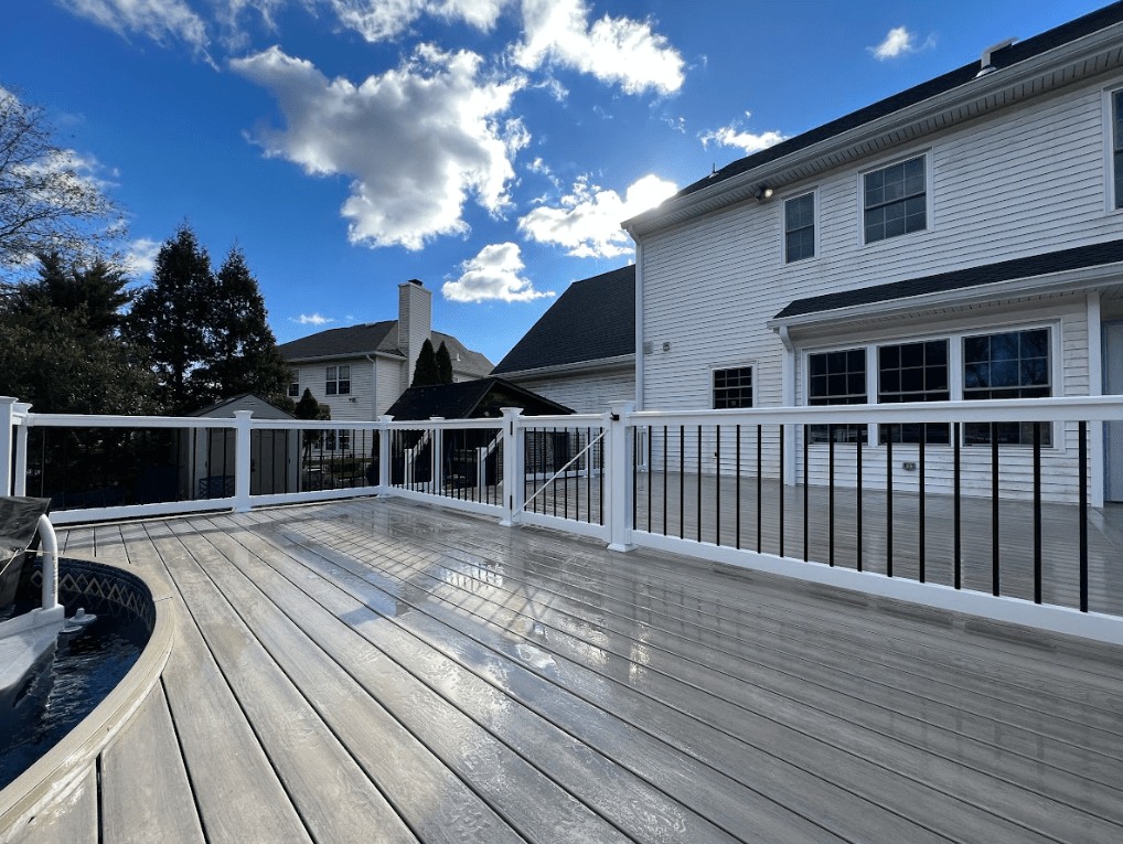 photo of a pool deck with composite decking materials, deck railing, and security gates - Pool Deck Contractors near me in PA